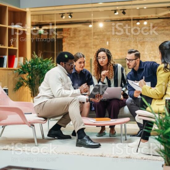 Multiethnic Young Group of People Brainstorming Together in a Meeting Room at the Office. Black Male E-commerce Coordinator Pitching His Ideas To Startup Management Board Members Using Tablet